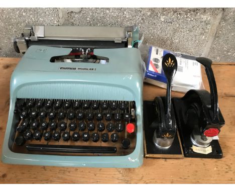 Two company stamp embossers including Askeys ice cream Ltd and an Olivetti Studio 44 typewriter.Condition ReportGood.