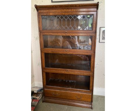 A five section oak bookcase with drawer to base. 160cms h x 87cms w x 36cms d.Condition ReportLacking glass to bottom shelf.
