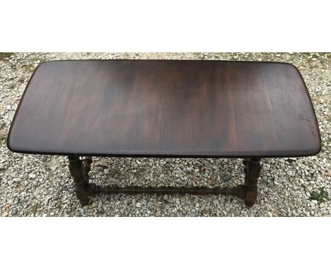 A mid century dark Oak Ercol style coffee table with turned supports. 105cms w x 46cms x 47cms h.Condition ReportSigns of use