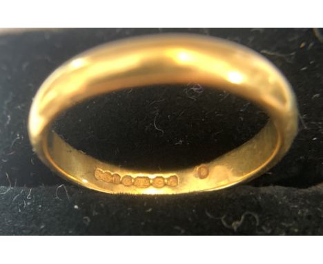 A 22ct gold wedding ring. 3.6gms. Size M. The band is 19mm wide. Good condition. 