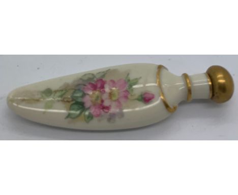 A late 19th/ early 20thC Royal Worcester lay down scent bottle of tongue shaped design with floral and gilt decoration. 9cms 
