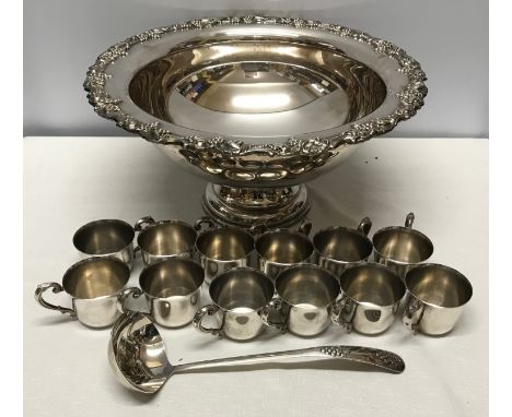 A large silver plated punch bowl with grapevine border decoration. 22cms h x 45cms w with a Sheridan E.P.S. silver ladle and 