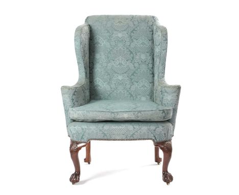 A GEORGE II WALNUT WING ARMCHAIRC.1735-40with scroll arms on shell capped cabriole front legs and claw and ball feet with sun