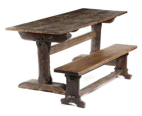 AN OAK REFECTORY TABLEEARLY 18TH CENTURY AND LATERthe boarded top with cleated ends on rustic end supports united by a stretc