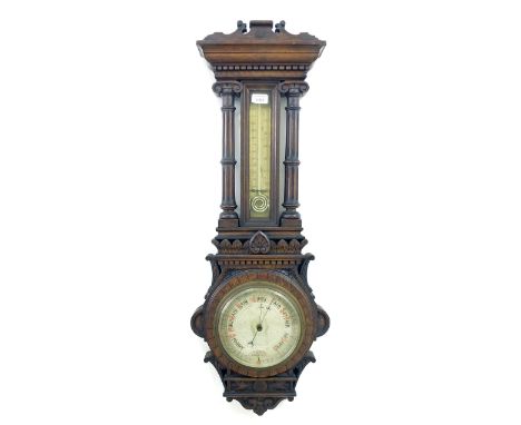 Oak cased aneroid barometer/thermometer, the 7" dial within a carved pillared case
