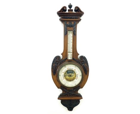 Mahogany aneroid barometer/thermometer, the 8" principal chapter ring enclosing a skeletonised centre, within a shield shaped