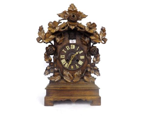 Black Forest two train cuckoo clock striking on a gong, the 6" dial within a chalet style stepped case carved with vine leave