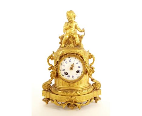 French gilt metal pillar two train mantel clock striking on a bell, within an ornate case surmounted by a seated cherub, 14.5