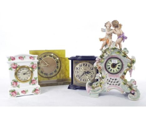 Porcelain cased balloon mantel clock timepiece, surmounted by playful winged cherubs over a rococo floral encrusted case, 11"