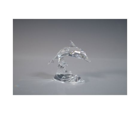This striking Swarovski crystal dolphin figurine, designed by Michael Stamey, showcases a graceful dolphin leaping through th