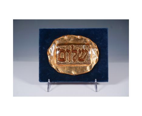 A beautifully handcrafted gilded glass Judaica plaque featuring the Hebrew word Shalom intricately embossed in relief against