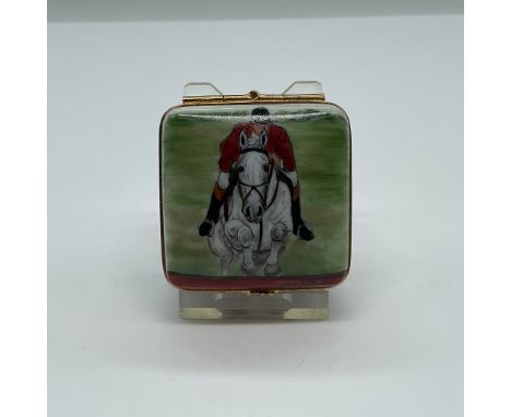 A fine Limoges France porcelain trinket box featuring a hand-painted equestrian theme. The lid depicts a show jumper riding a