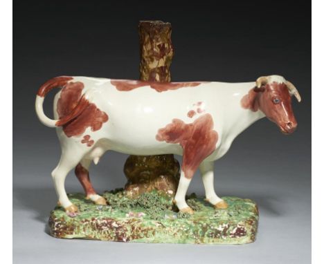 A STAFFORDSHIRE EARTHENWARE SPILL HOLDER MODEL OF A COW,  C1820  with overglaze enamel painted decoration, 27cm h++Localised 