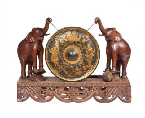 A BURMESE CARVED HARDWOOD AND GILT BRASS DINNER GONG, EARLY 20TH C  the base   with a central flower with carved and pierced 