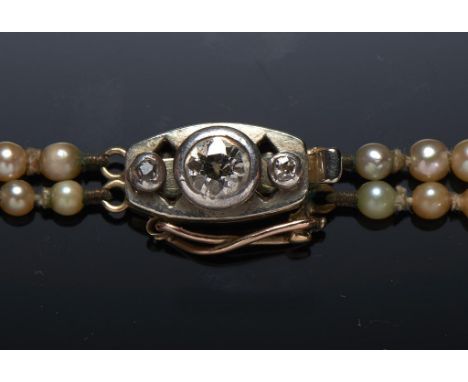 A CULTURED PEARL AND DIAMOND NECKLACE with double strand of approx 3-7mm graduated round cultured pearls and diamond set clas