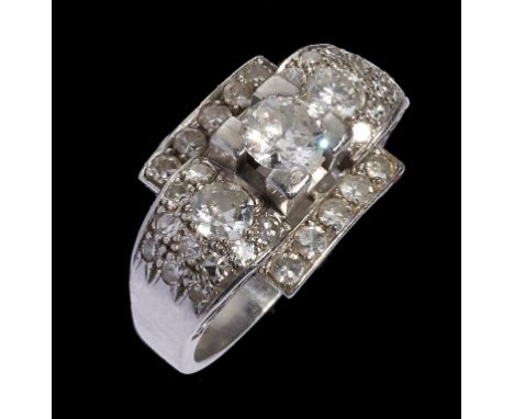 A DIAMOND COCKTAIL RING of geometric design with a central line of three graduated round brilliant cut diamonds flanked by ro