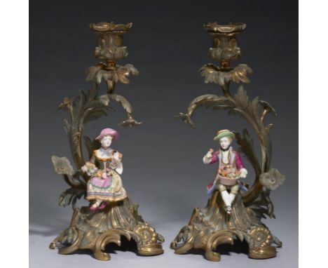A PAIR OF MINTON BONE CHINA CANDLESTICK FIGURES AND CONTEMPORARY REVIVED ROCOCO ORMOLU CANDLESTICKS, C1830 28cm h Literature: