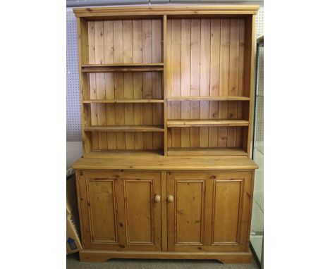 A 20th century pine kitchen dresser. The upper section divided in half with eight adjustable drawers, the base with a pair of