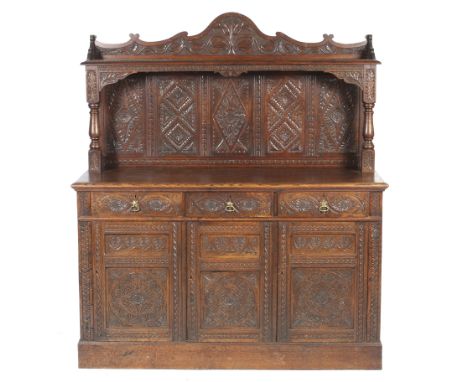 A carved oak sideboard dresser. The carved back with shelf above with a decorative carved arched frieze. The shelf having tur