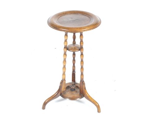 A walnut jardiniere stand. The circular top with a burr walnut panel to the centre, raised on three turned bobbin supports un