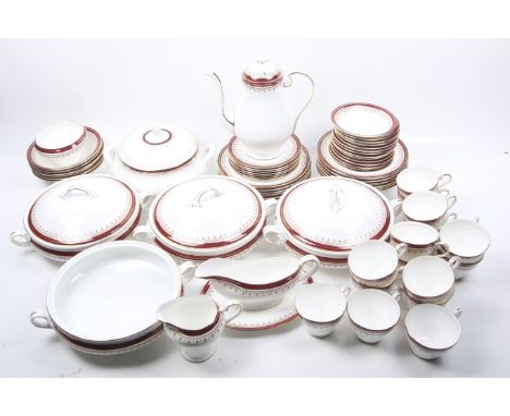 An Aynsley dinner service in white with red and gilt borders. Includes plates, bowls and five round tureens four of which hav