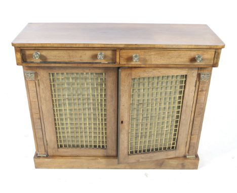 A 20th century mahogany chiffonier. With two drawers over a cupboard, the doors covered in decorative brass mesh with fabric 