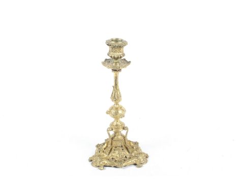 A 19th century elaborate gilt metal candlestick. Decorated with vines and scrolls, the tripod base featuring dragons and clas