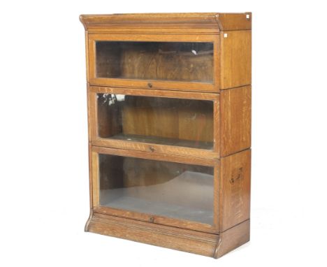 An oak globe Wernicke style freestanding bookcase. The three sections with fold-in glazed doors, on a moulded base, H122.5cm 