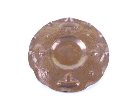 An Arts and Crafts copper circular tray planished / hammered finish. In the Newlyn School style, with a beaten texture and fl