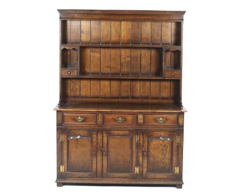 An early 19th century oak Welsh Dresser. Of peg-joined construction, rough sawn back boards, moulded canopy top, upper shelf,