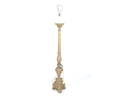 A carved gilt wood standard lamp. With a turned column support and scrolling tripod base, topped with a fake candle, H63cm (e