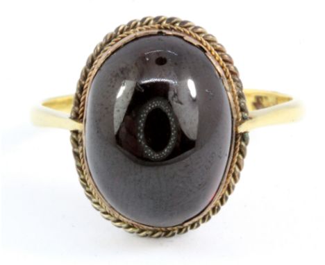 An 18ct yellow gold cabochon cut garnet set ring, (W).