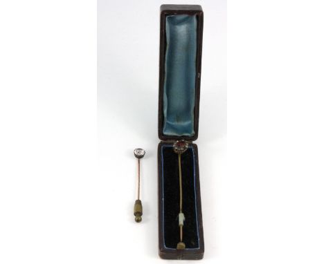 Two early stone set stick pins in an antique box.