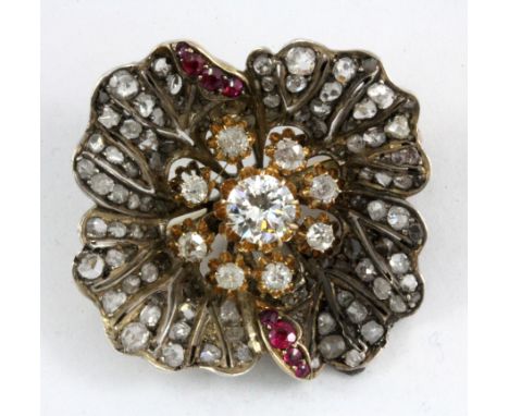 A yellow and white metal (tested silver and gold) diamond and ruby set brooch, approix 1ct centre diamond, L. 3.1 x 3.5cm.