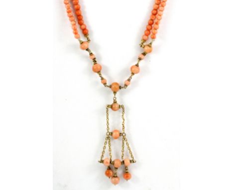 An Edwardian boxed coral bead necklace on a yellow metal clasp (tested 9ct gold), L. 70cm.