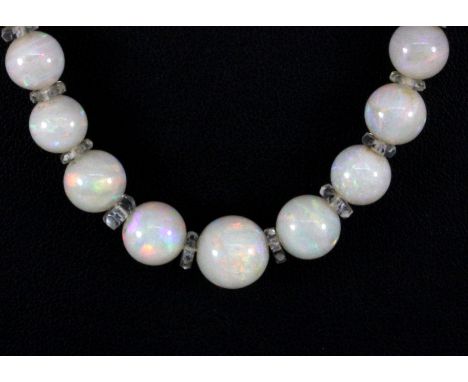 A polished opal bead graduated necklace on a yellow metal (tested gold) diamond set clasp, L. 56cm.