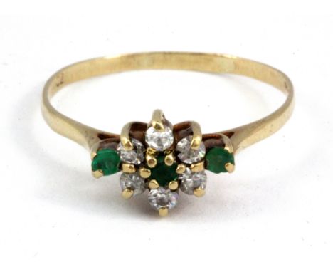 A 9ct yellow gold emerald and white stone set cluster ring, (R.5).