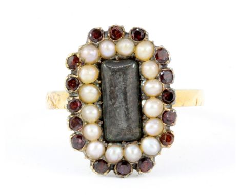 An antique 18ct yellow gold garnet and seed pearl set mourning ring, (Q).