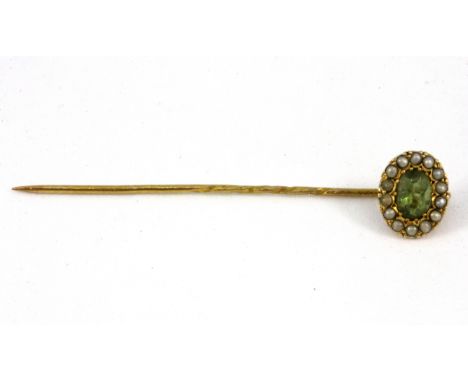 A yellow metal (tested high carat gold) peridot and seed pearl set stick pin.