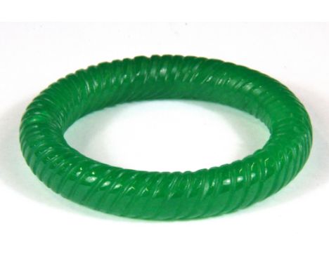 A Chinese carved green jade bangle, Internal Dia. 6cm.