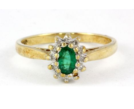 A 9ct yellow gold emerald and diamond set cluster ring (M.5).