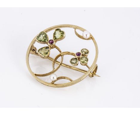 An Edwardian peridot, ruby and pearl gold open work Art Nouveau brooch, in the suffragette colours, marked 15 ct and a scroll