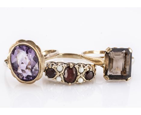 Three gem set dress rings, including a smoky quartz rectangular cut example, another garnet and pearl and an amethyst ring, 1