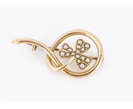 An Edwardian 15ct gold and seed pearl clover leaf brooch, the three leaf clover set with seed pearls, with in a open worked k