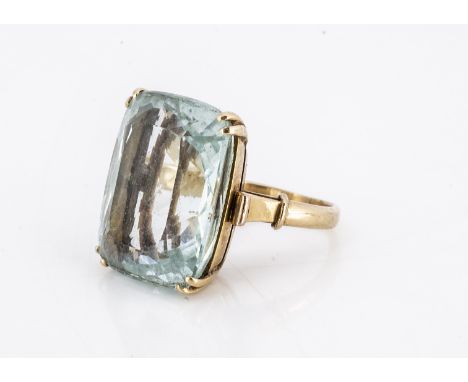 A ;large aqua marine dressing ring, caw set, on a yellow metal shank, the rectangular cut stone measuring 20cts approx, ring 