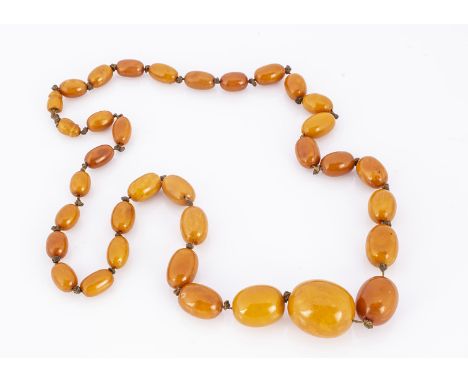 A 19th  century string of graduated butter scotch amber beads, oval beads, largest 2.6 cm long by 2.3 cm wide, smallest 1.4 c