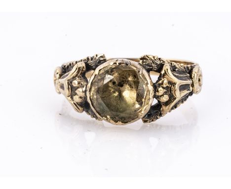 A 19th century topaz posy ring, the circular mixed cut in rubbed over settings, with pierced fleur de lys shoulders, on a ree