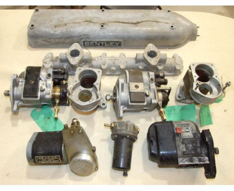A collection of restored and unrestored car parts, probably for vintage Bentley cars, including three magnetos, Bentley cylin