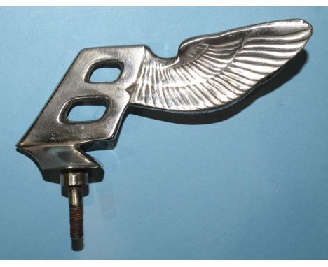 A Bentley winged 'B' mascot, the 'B' leaning backwards, stamped with Reg 82m907, 14cm long.