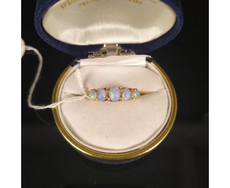 An 18ct gold ring set with five opals, in scroll work setting, size M, approx 4g (damage to one opal, significant wear to sur